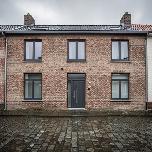Jaren-50 rijtjeshuis met donkergrijze antraciet kunststof kozijnen in een straat in Bussum